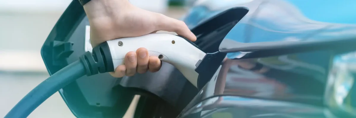 man-plugging-in-charger-into-an-electric-car-at-charge-station